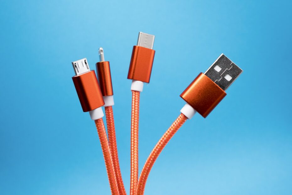 Cable naranja trenzado con conectores Micro-USB, Lightning, USB-C y USB-A sobre fondo azul